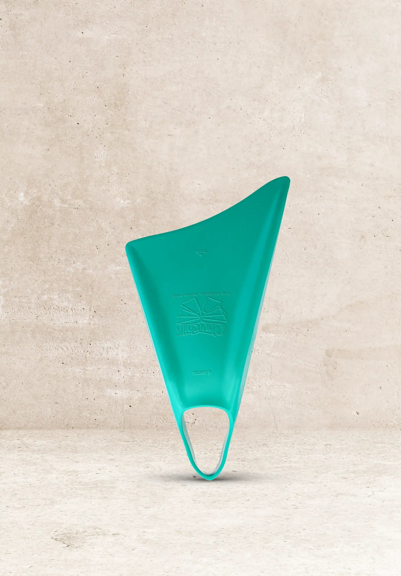 Teal Churchill swim fins, original design, against concrete background